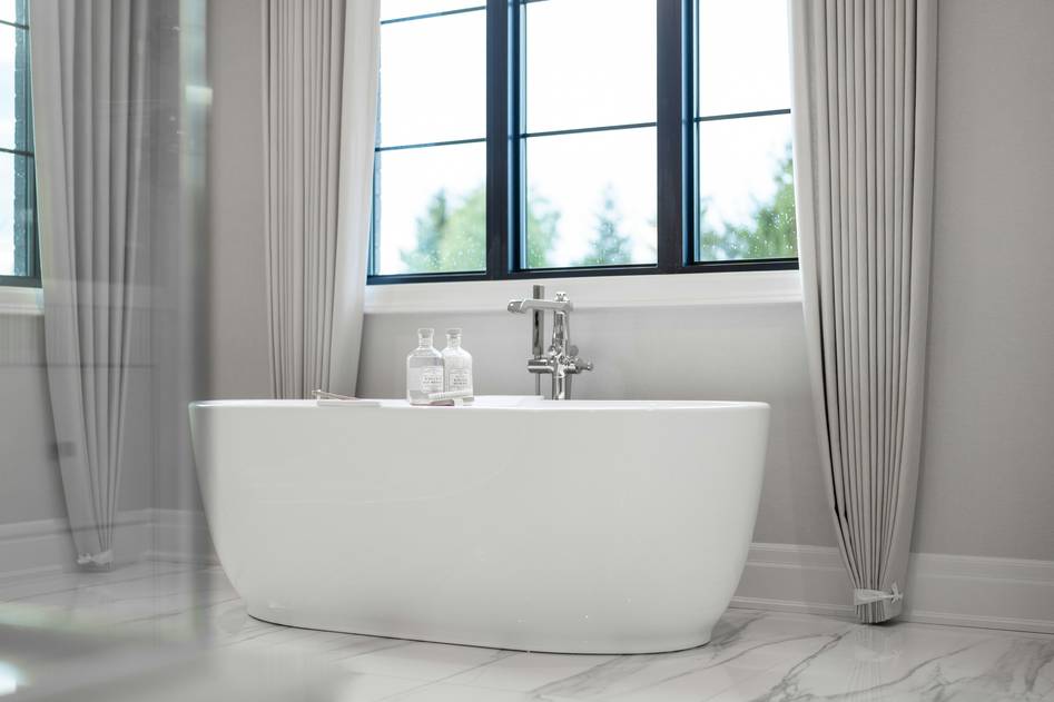 Elegant clawfoot freestanding tub with natural light and marble surroundings